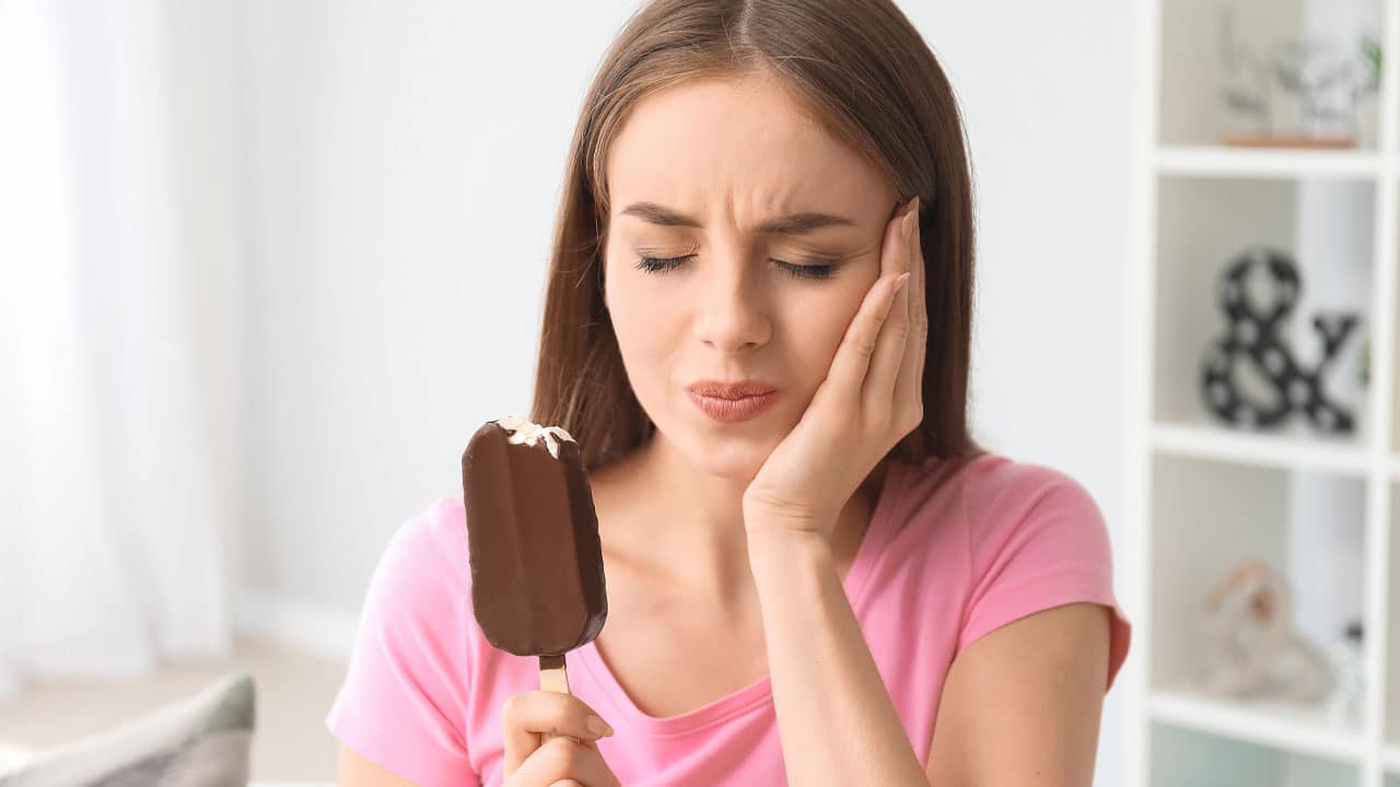 Woman eating ice cream with sensitive teeth